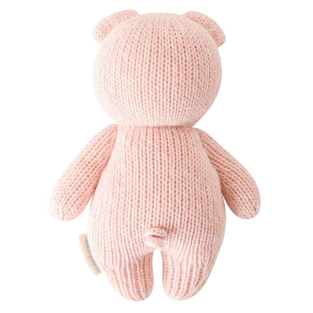 Knitted pink teddy bear on a white background