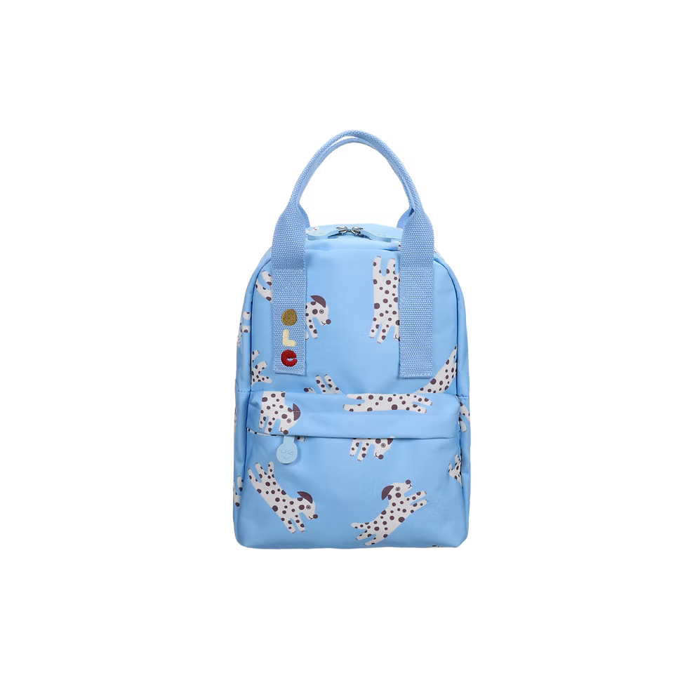 A light blue backpack featuring a playful print of Dalmatian dogs, with two top handles and a front zippered pocket, shown against a plain white background.