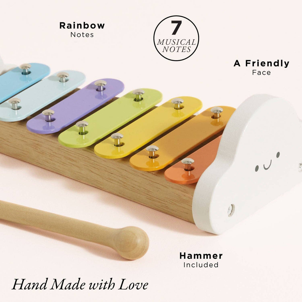 Colorful wooden xylophone with a cloud-shaped mallet on a light pink background