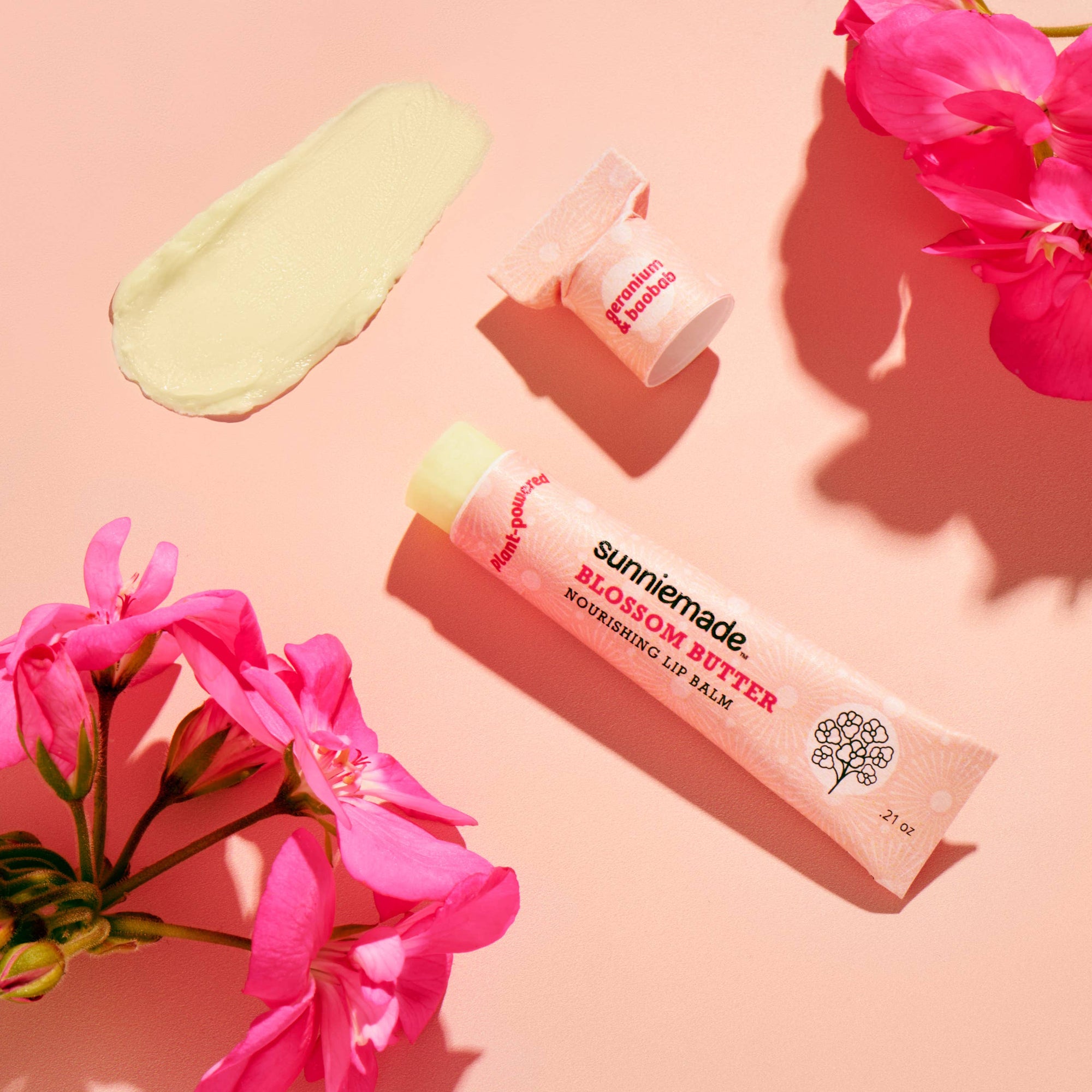 lip balm  tube with pink flowers on a pink background