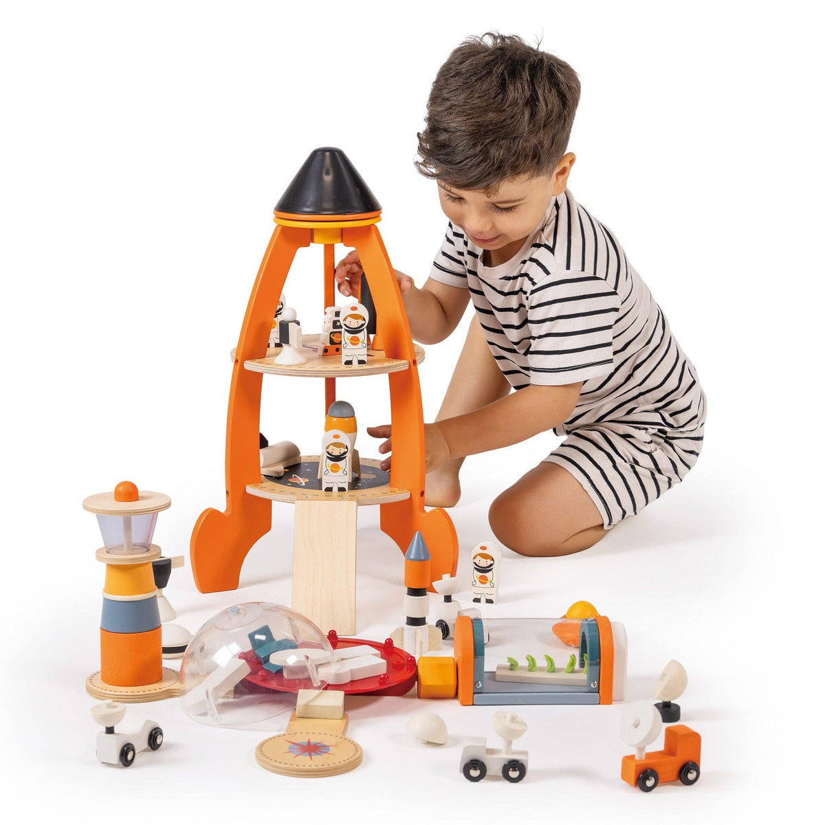Child playing with a toy space station set on a white background