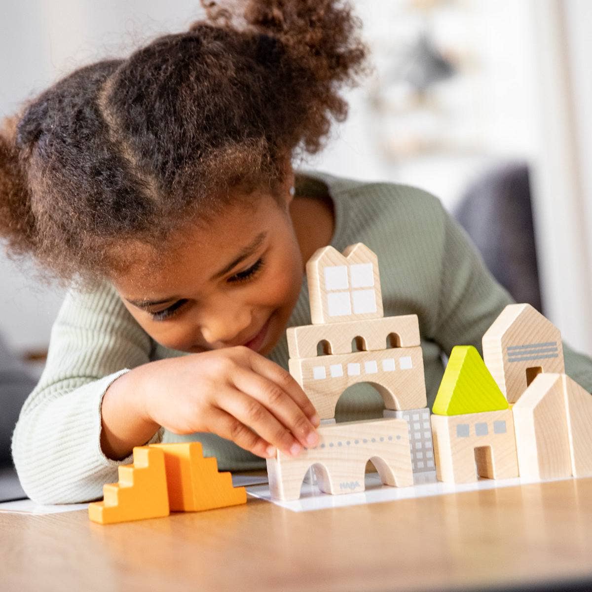 Child playing with wooden building blocks on a table