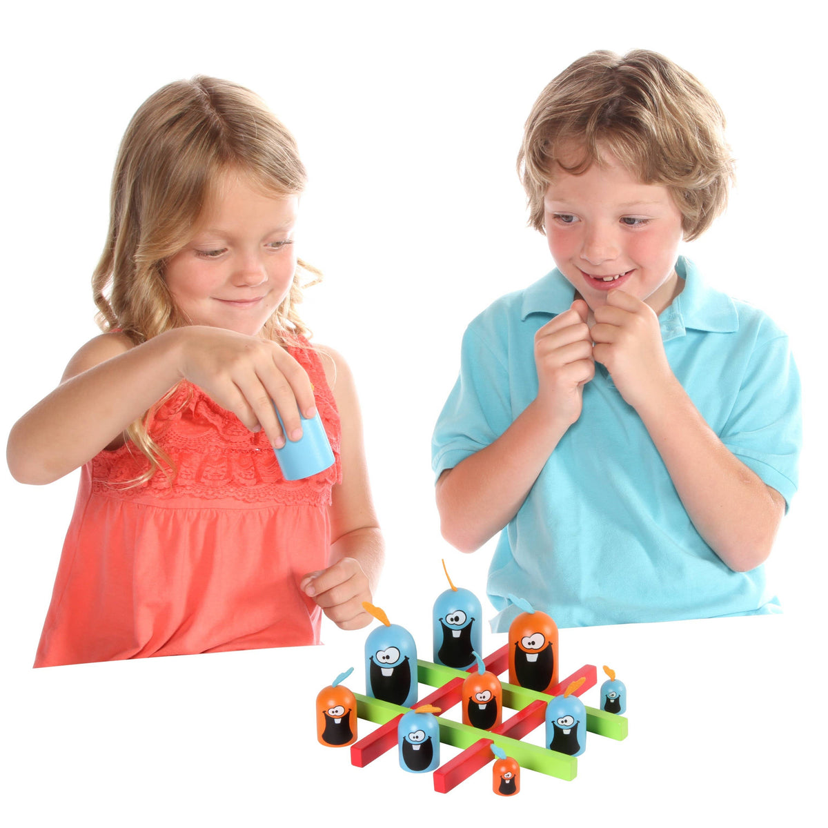 Two children playing with a colorful wooden peg game on a white background. The girl on the left in a coral dress is holding a blue peg, and the boy on the right in a light blue polo shirt is looking on with a thoughtful expression.