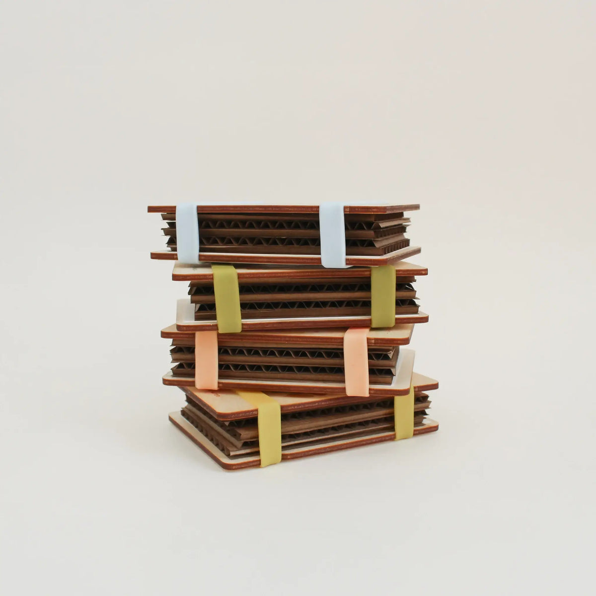Stack of wooden flower press with colorful bands on a light background