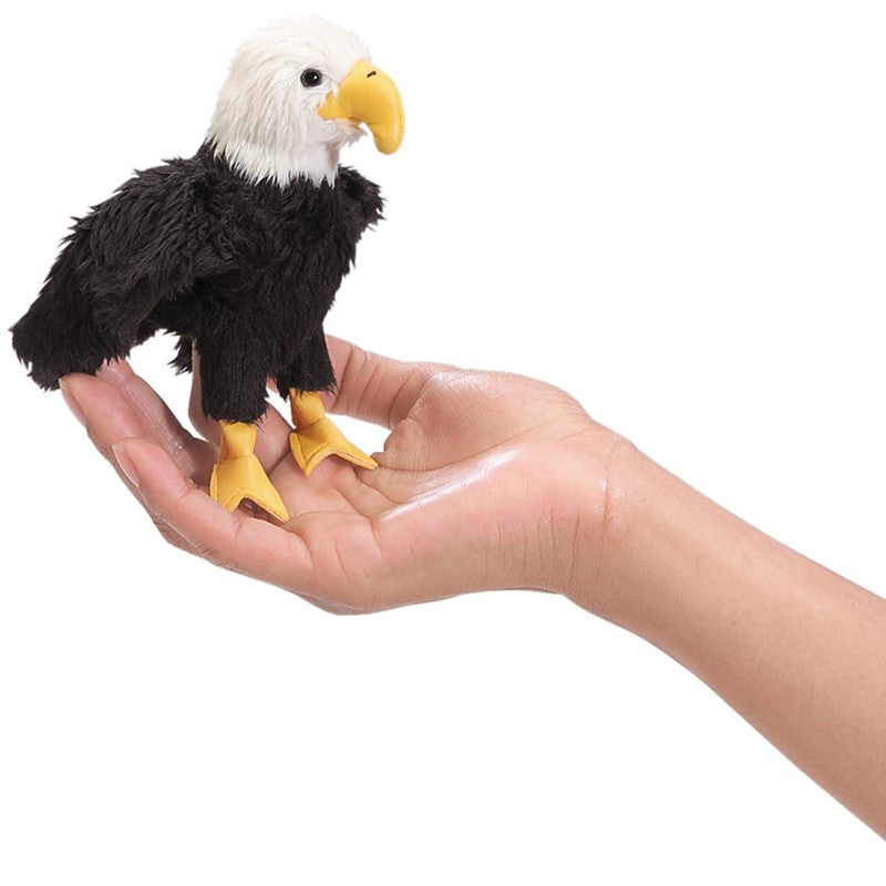 Plush eagle toy held in a hand against a white background