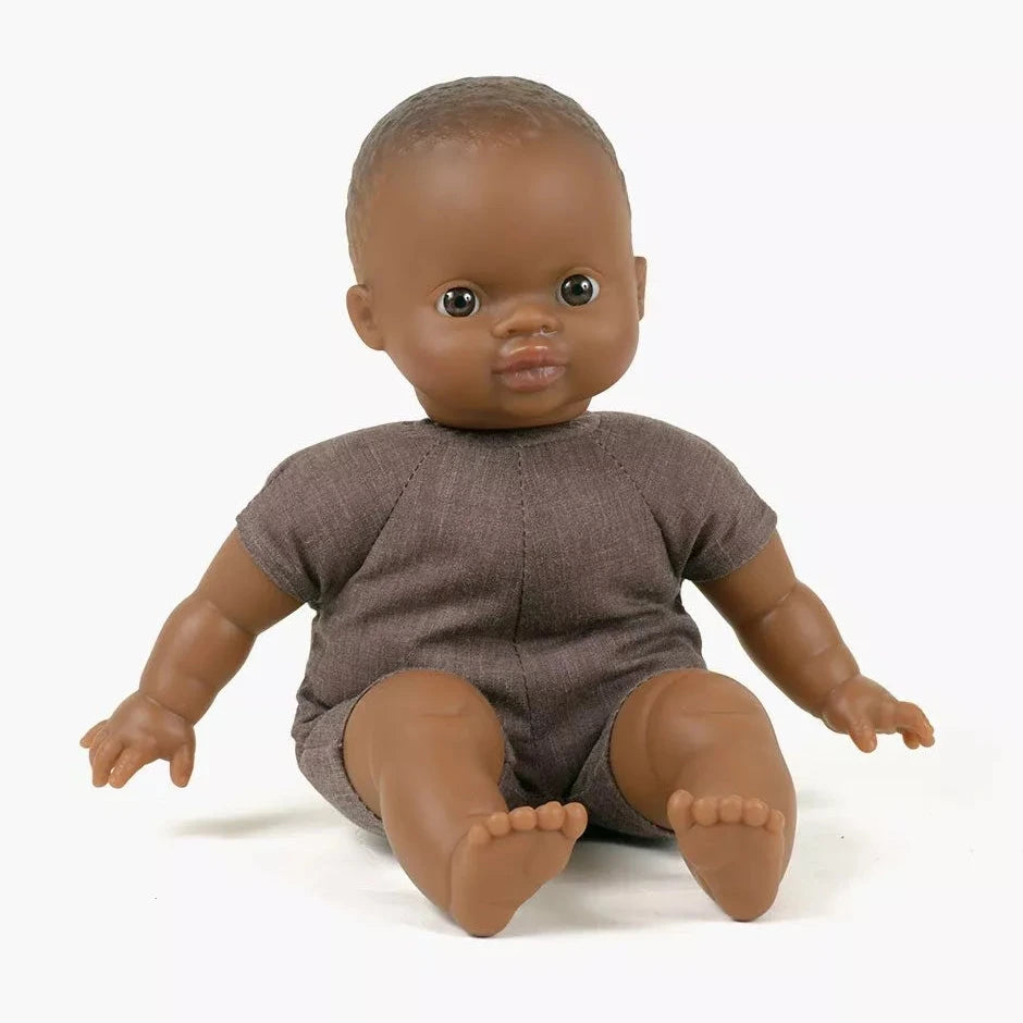Doll with brown skin and brown outfit on a white background