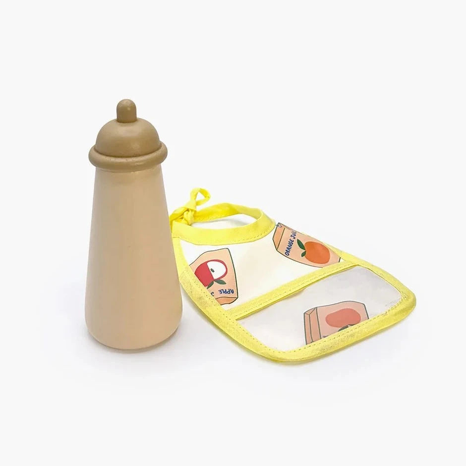 A toy bottle and bib set on a clean white background. The toy bottle is made of natural wood with a beige finish, and the bib has a yellow border, a clear front pocket, and a playful food print.