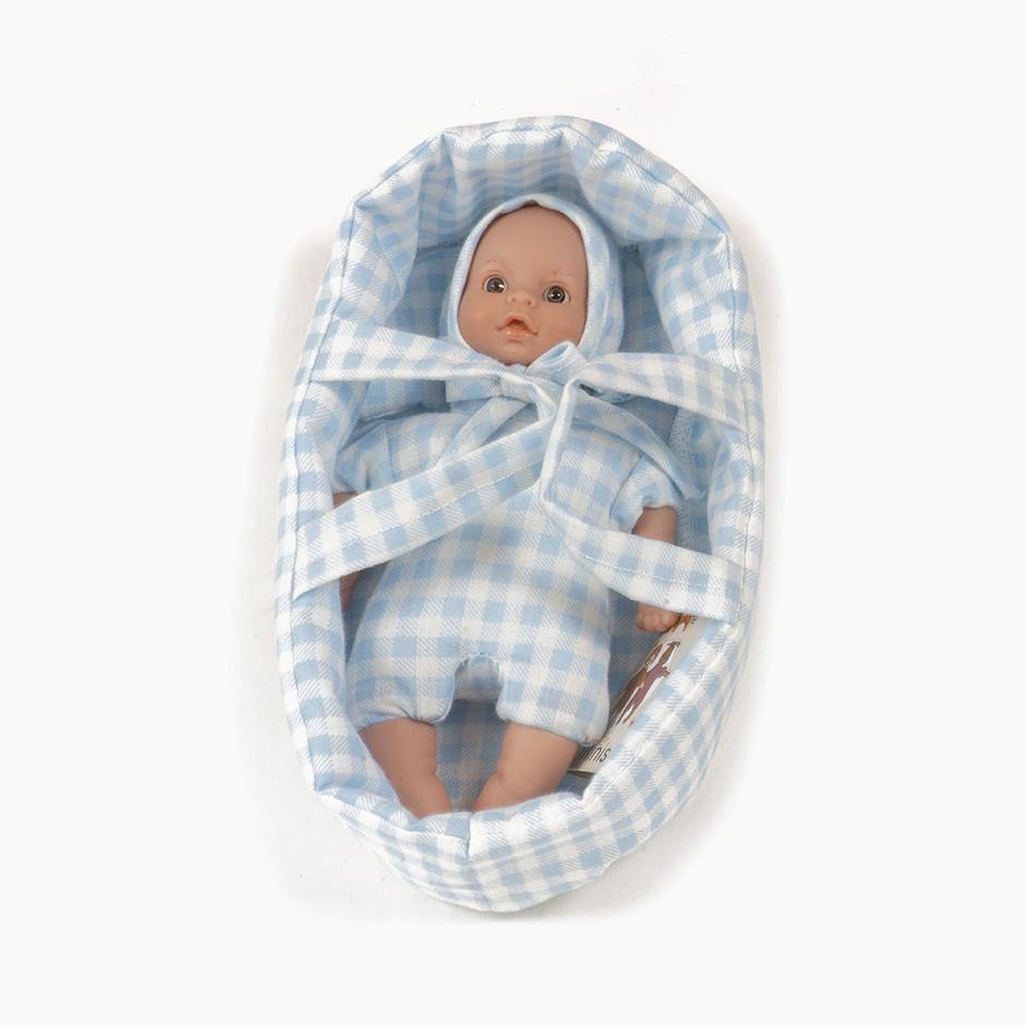 Baby doll in a purple checkered crib on a white background