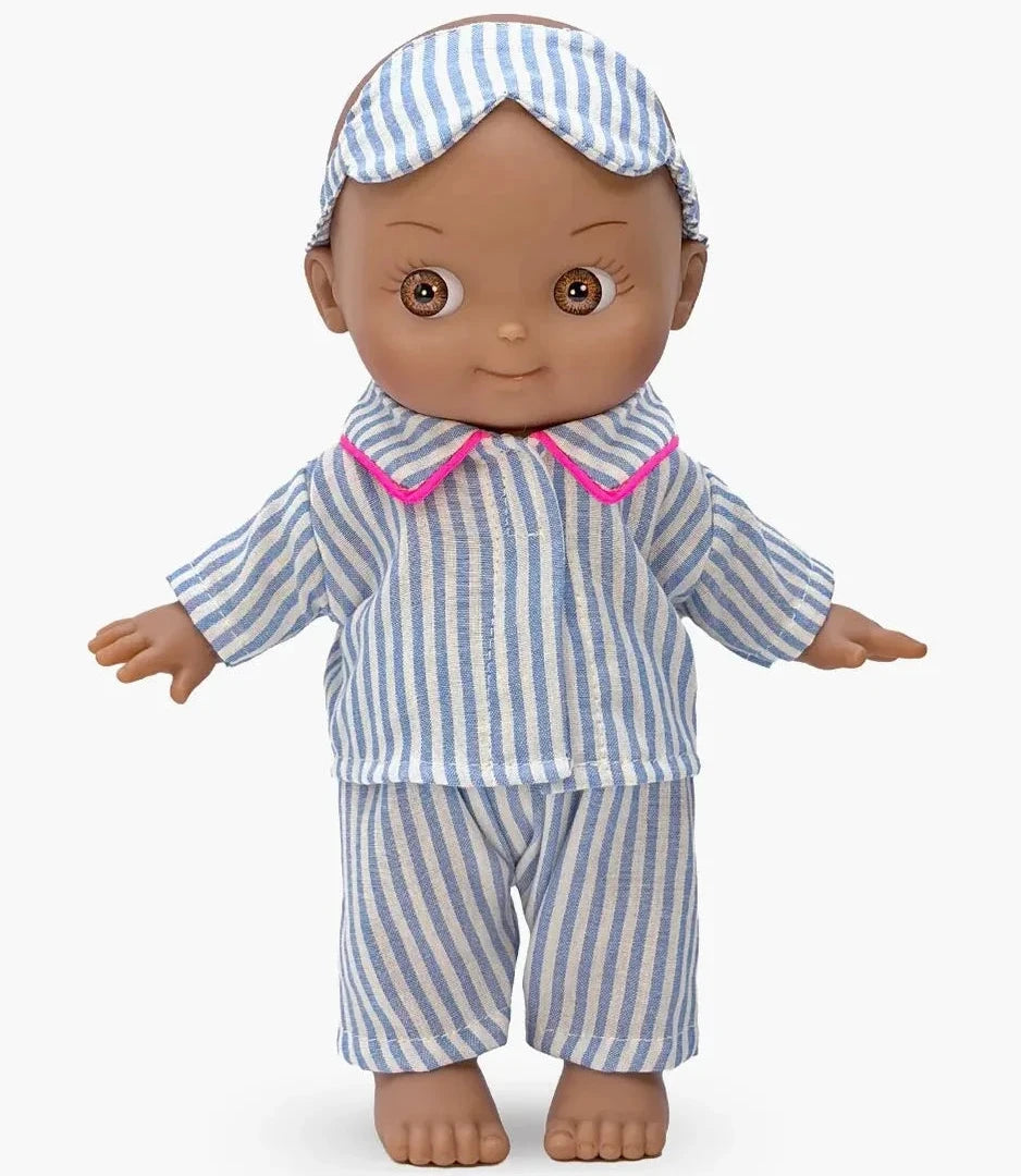 A doll wearing a blue and white striped pajama set with a pink collar trim and a matching striped headband, shown against a light gray background.