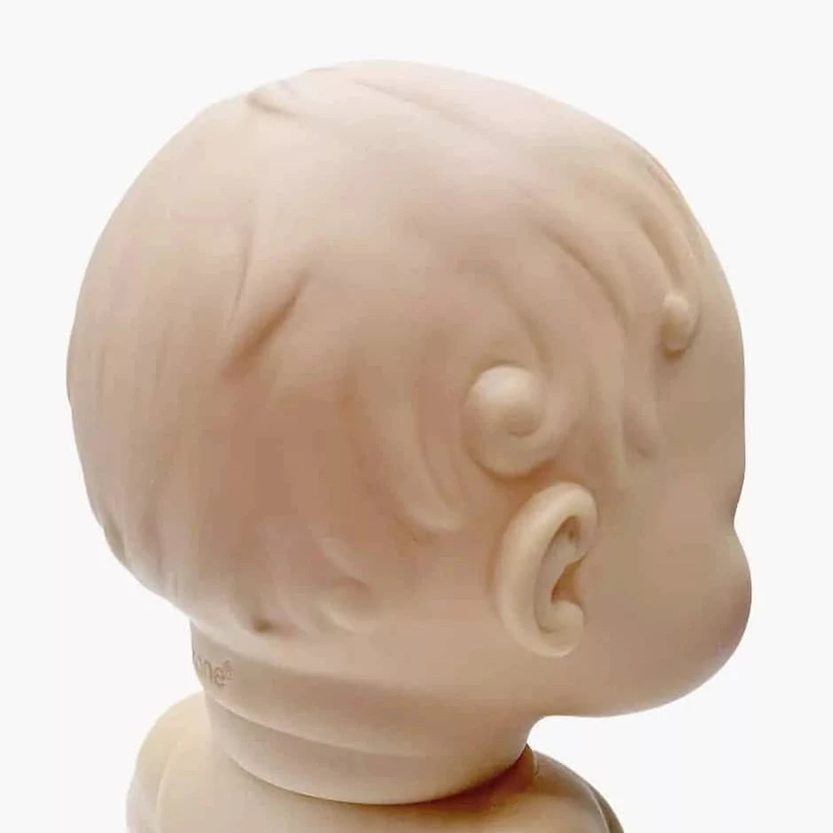 Close-up of a beige baby doll head on a white background