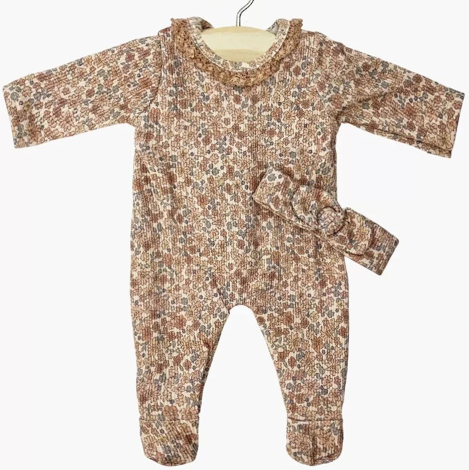 Floral-patterned toddler doll onesie on a hanger against a white background