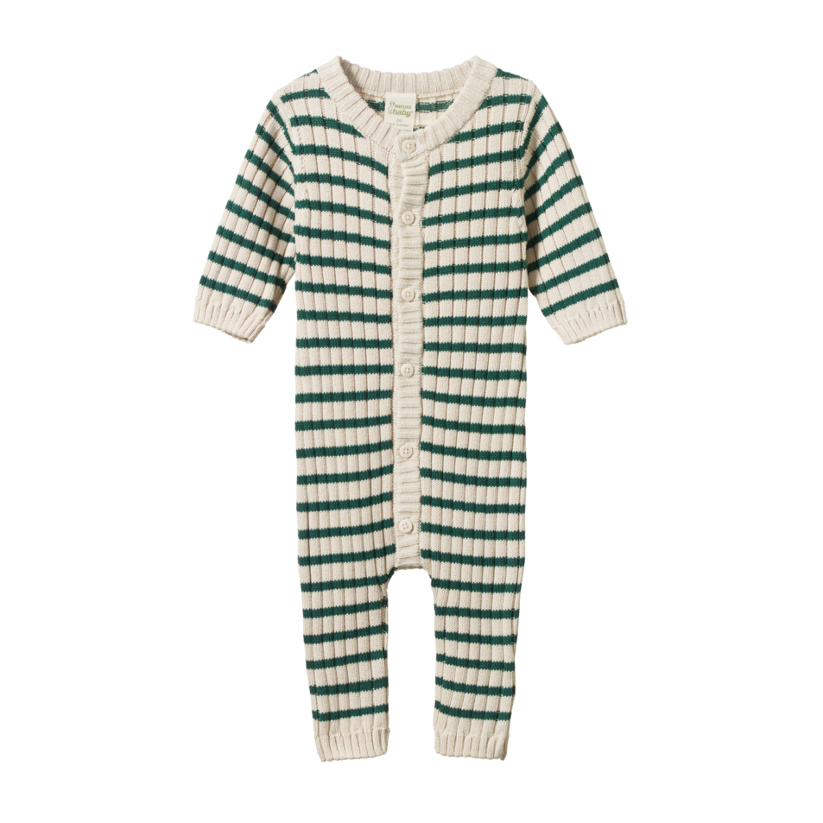 Child in a striped outfit standing next to a wooden chair outdoors.