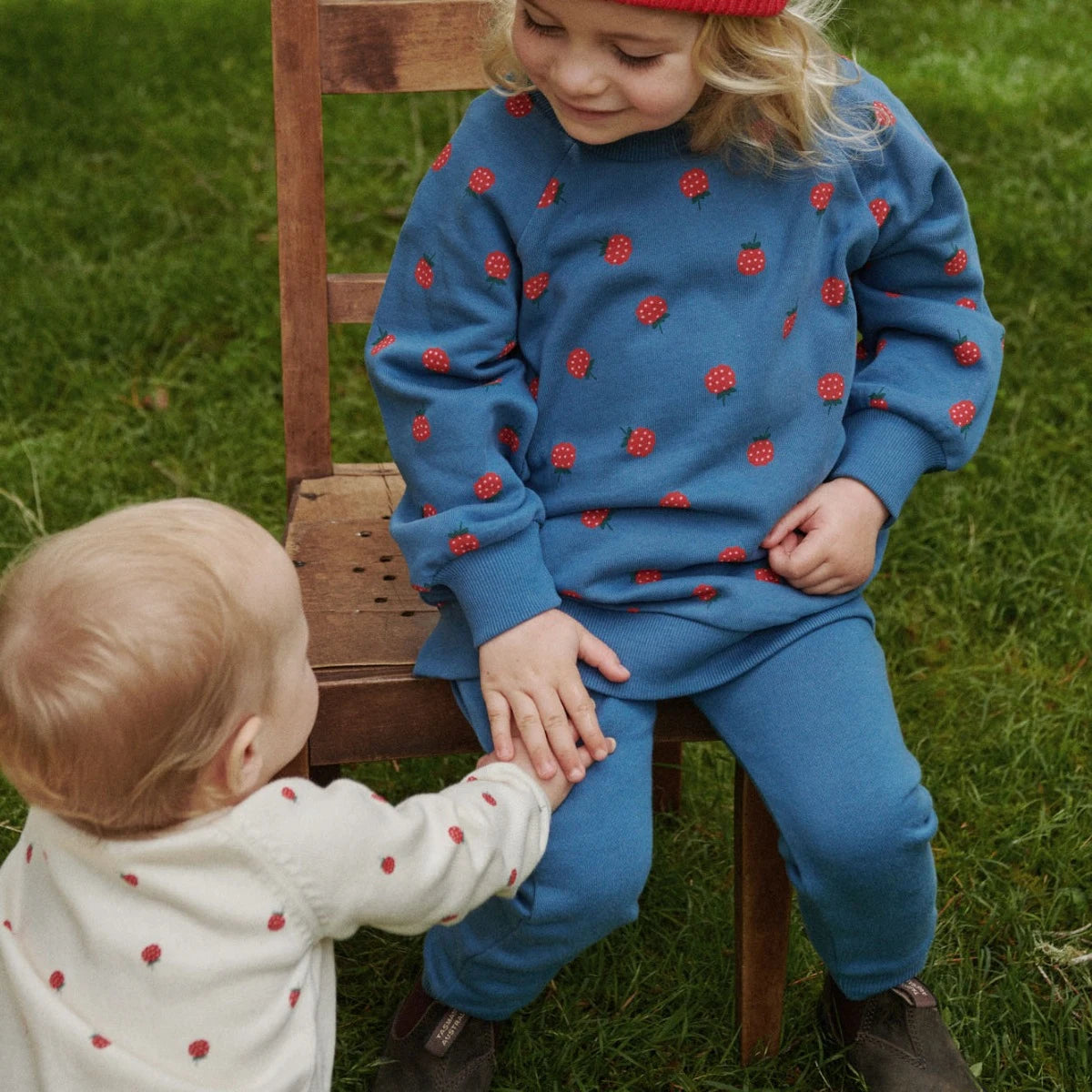 Child wearing a brown sweatshirt with fox patterns and a matching beanie outdoors.
