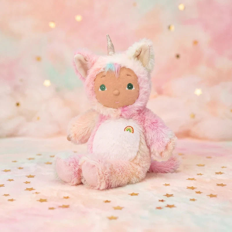 Stuffed toy in a pink unicorn costume on a soft, pastel background with gold stars.