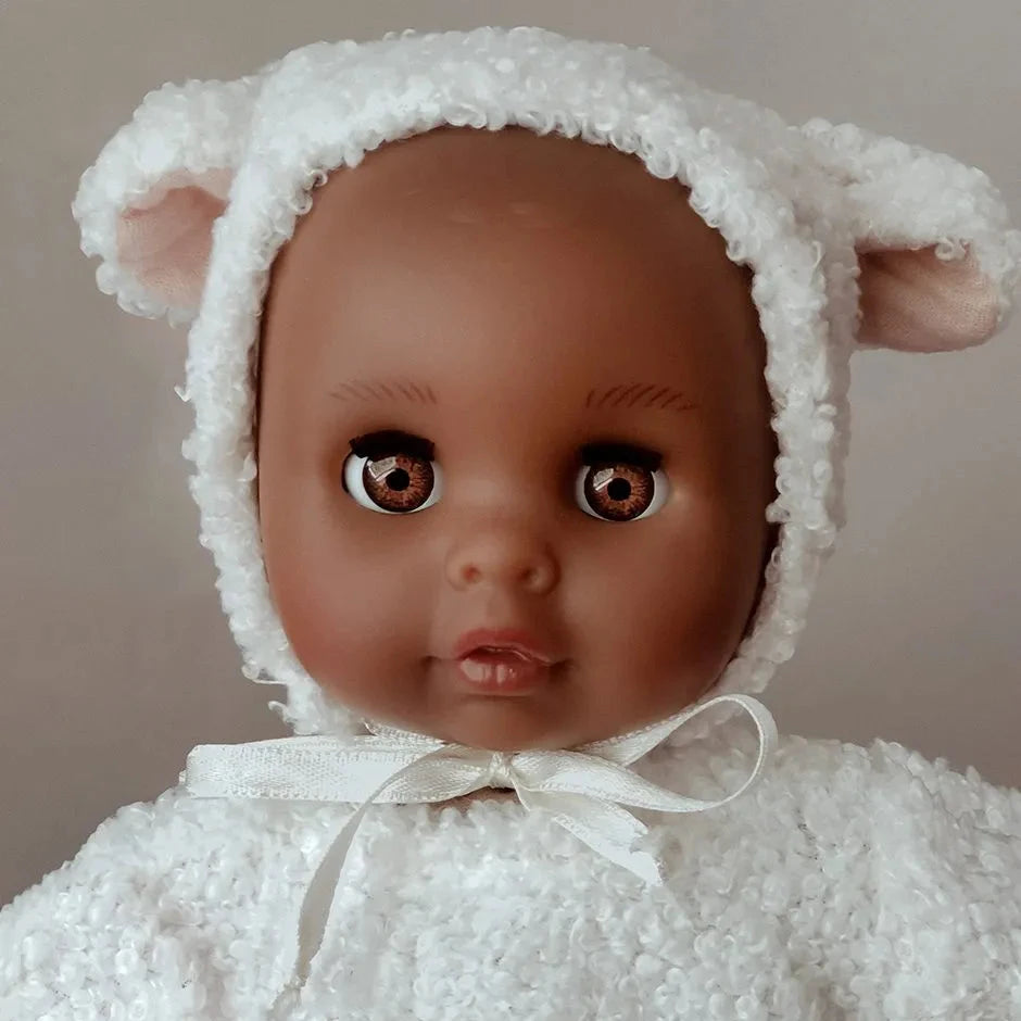 Doll wearing a white fluffy outfit with bear ears on a white background
