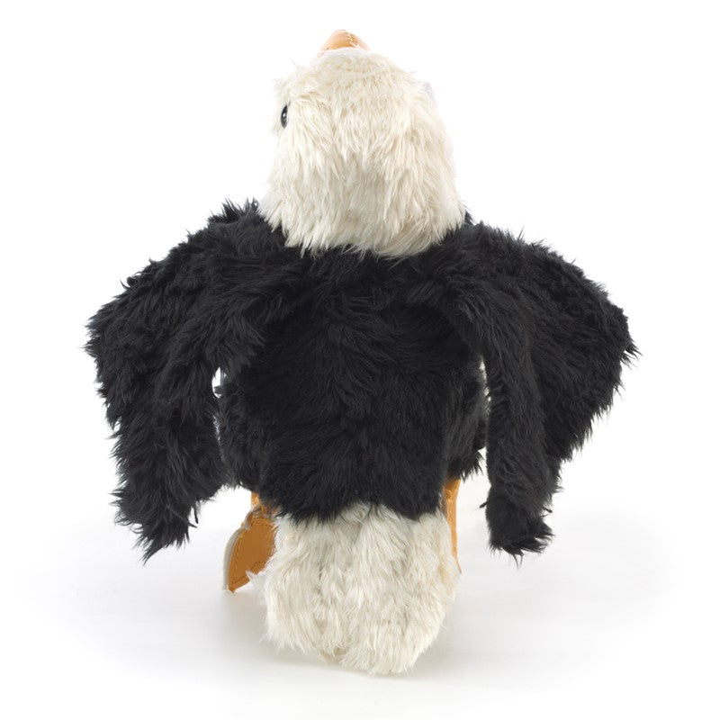 Plush eagle toy held in a hand against a white background