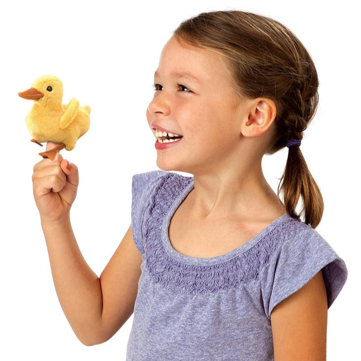 Young girl holding a plush duck toy against a white background