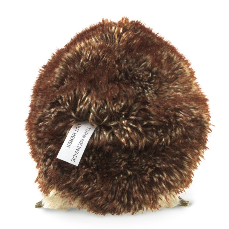 Small plush hedgehog toy with a tag on a plain background