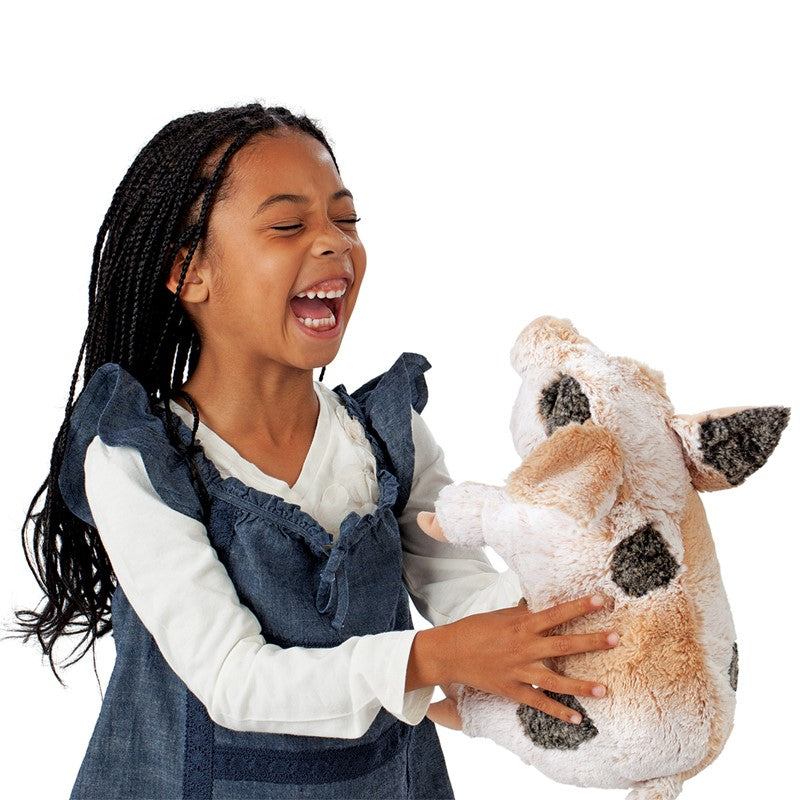 Young girl holding a plush pig toy against a white background