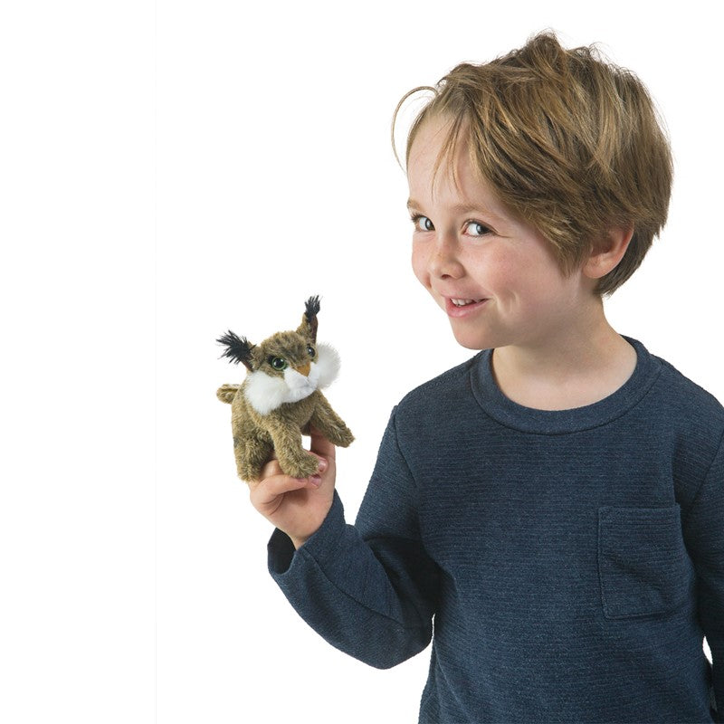 Child holding a bobcat finger puppet on white background