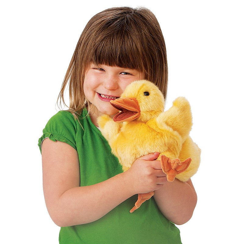 Child holding a plush duck toy against a white background