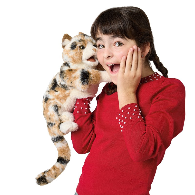 Girl in red sweater holding a plush cat toy on a white background