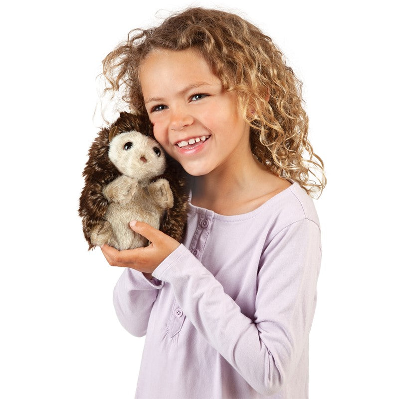 Child holding a plush hedgehog toy against a white background