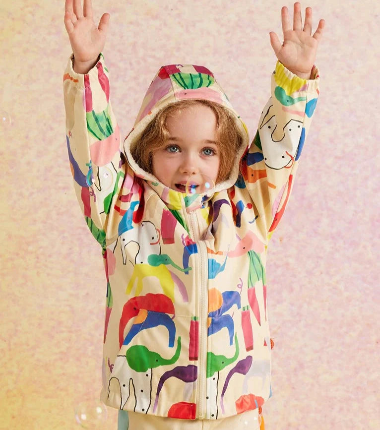 Child standing with elephant print raincoat with pink background