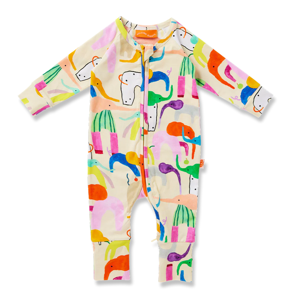Baby wearing a colorful outfit with animal prints on a yellow background