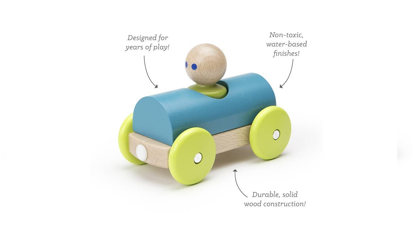 Child playing with a wooden toy car on a table