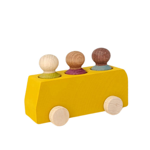 A child playing with a yellow wooden bus toy that has figures in gray, plum, and lime colors.