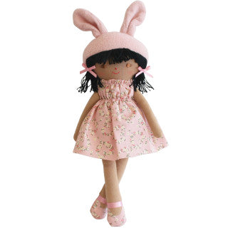 Doll with black ponytail with darker skin tone in pink dress