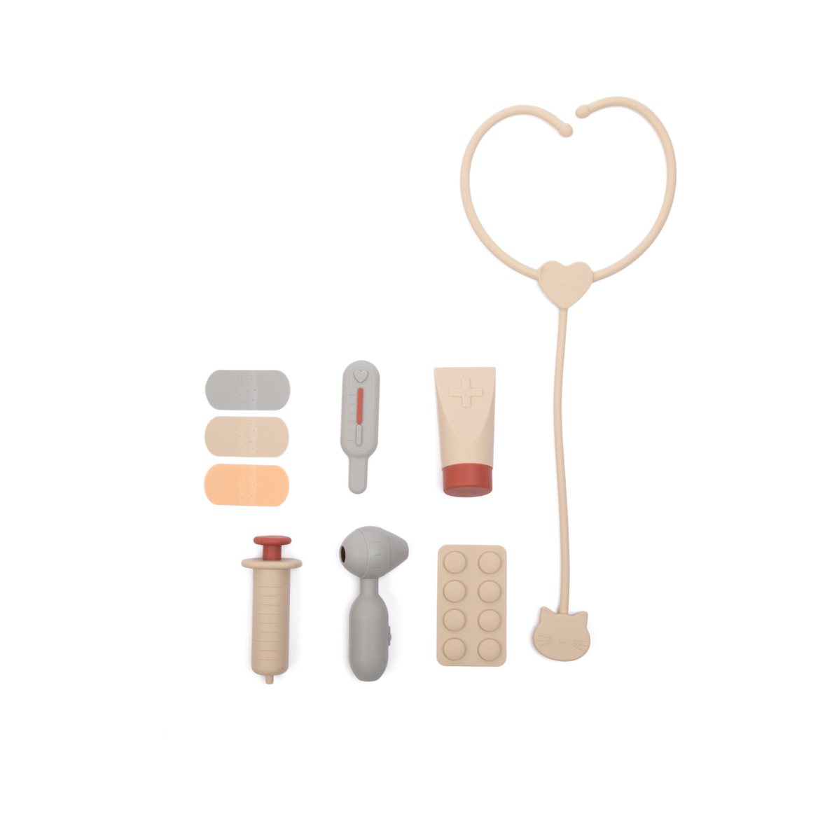 A silicone doctor set including a stethoscope, syringe, thermometer, otoscope, blister pack, ointment, bandaids, and a cotton medical tote bag, all in neutral colors.